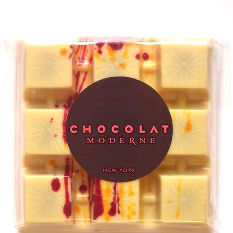 White chocolate bar filled with passion fruit caramel scented with cardamom. Speckled with natural red and orange color for dazzling effect. Delightful, made in New York City.  Gluten free, alcohol free, wheat free.   wt: 2.5 oz.